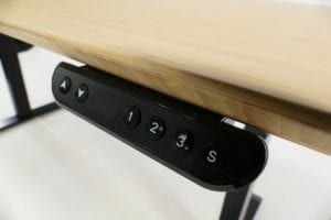 close up of black stand desk controller on bamboo desk