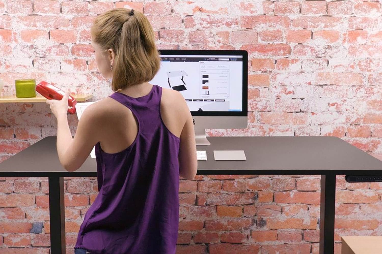 woman stapling documents at standing desk