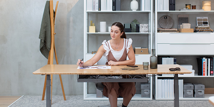 woman drawing while seated at desk