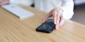 woman using phone on wireless charging desk