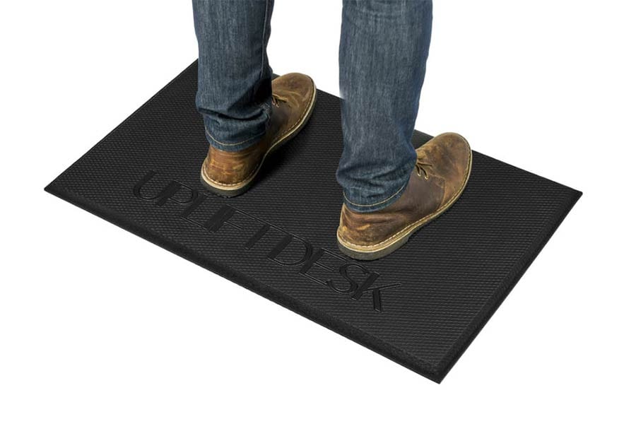 brown boots on standing desk anti fatigue mat