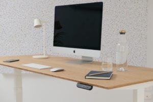bamboo standing desk with lamp, computer, notebook